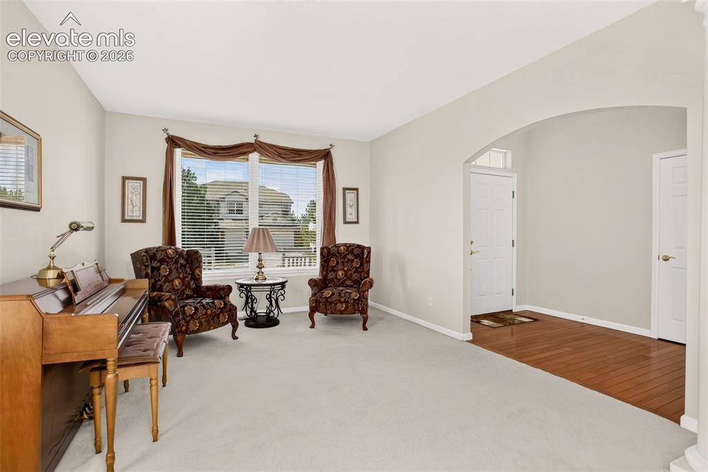 Image 6 of 42: Arched entryway leading to a foyer with wood-finish flooring