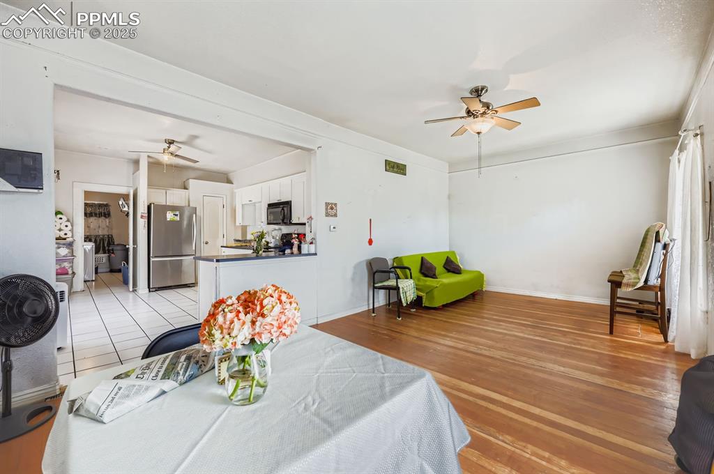 Image 4 of 10: Dining area with a ceiling fan and light wood-style floors