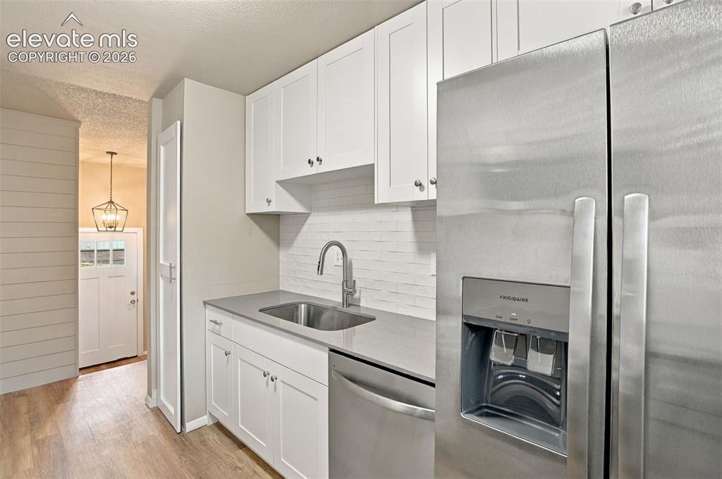 Image 15 of 50: Kitchen featuring white shaker-style cabinetry, stainless steel appliances,