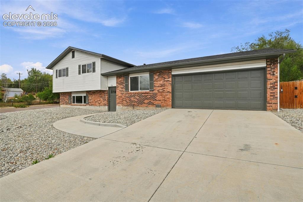 Image 2 of 50: Split-level exterior featuring a combination of brick and horizontal siding
