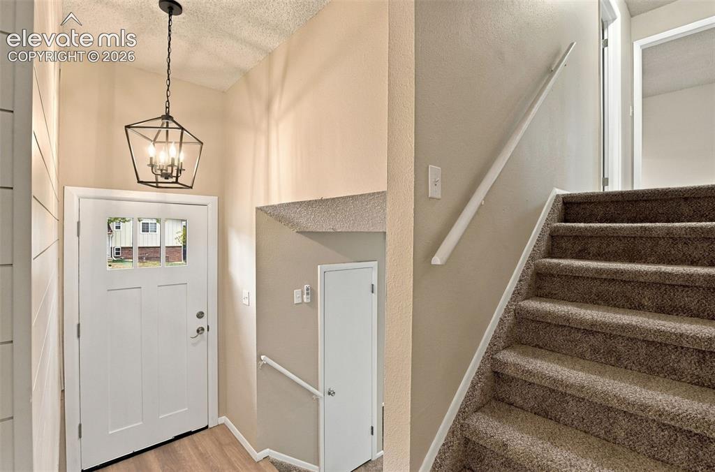 Image 20 of 50: Entryway featuring a white exterior door with window inserts, a geometric m