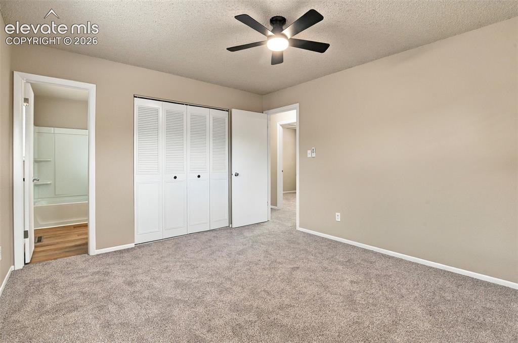 Image 4 of 50: Neutral-toned interior featuring wall-to-wall carpeting, a multi-blade ceil