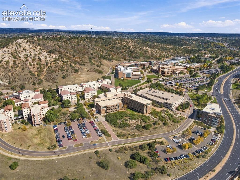 Image 41 of 50: Aerial perspective featuring multi-story commercial buildings, paved surfac