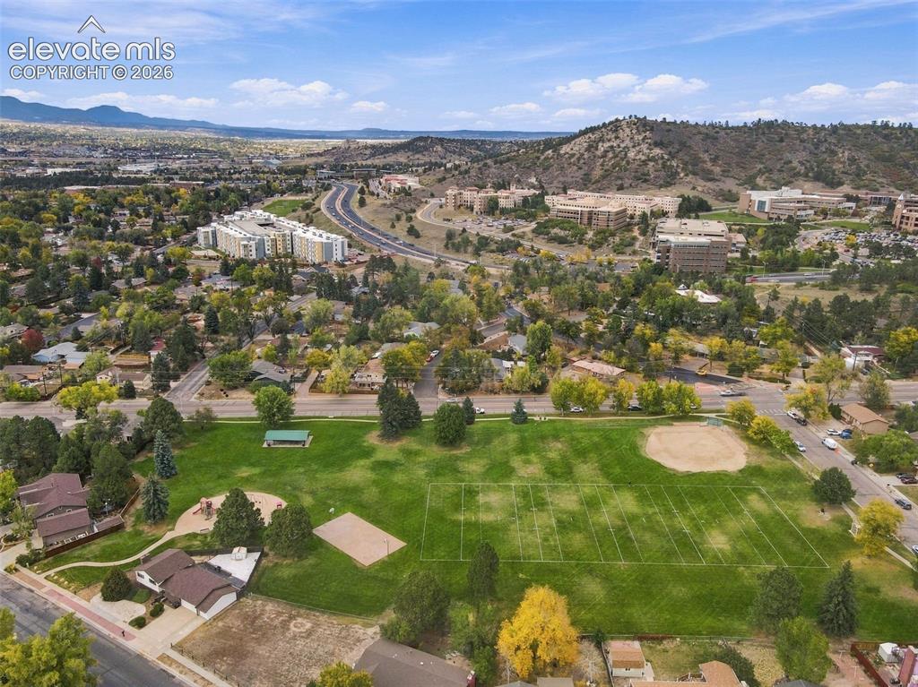 Image 45 of 50: Aerial perspective featuring an expansive public park with a manicured athl