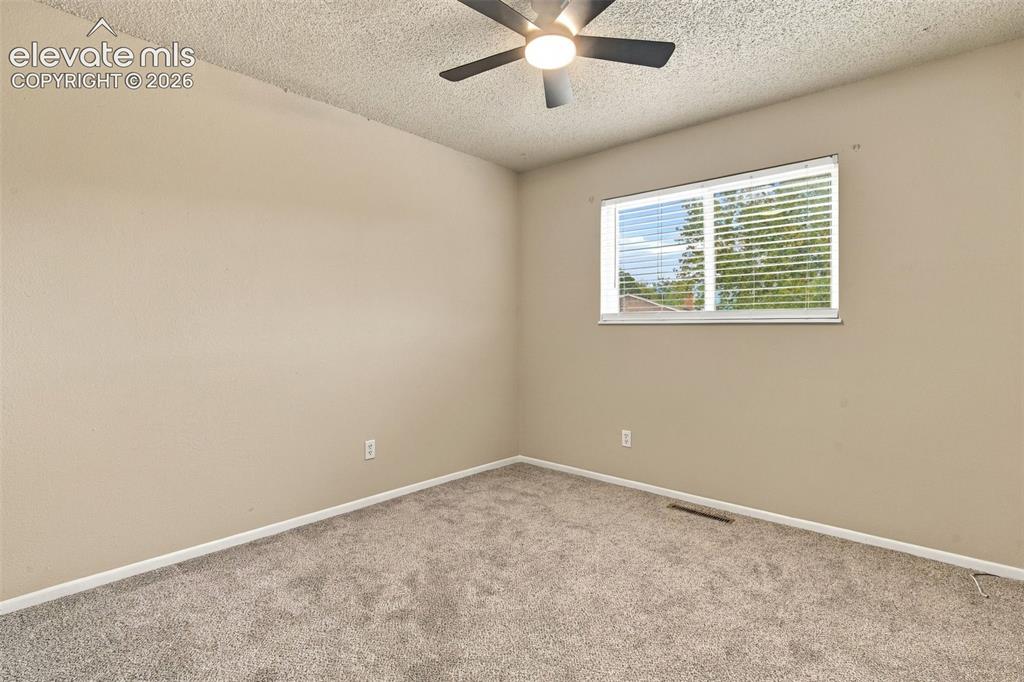 Image 7 of 50: Neutral wall finishes, textured ceiling, installed ceiling fan with light f