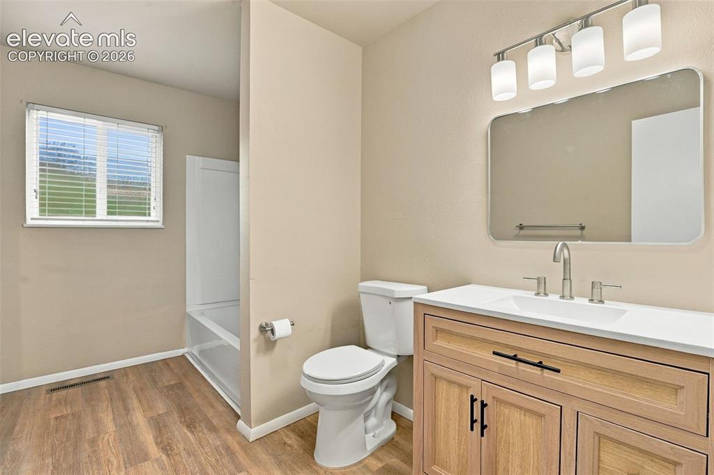 Image 9 of 50: Bathroom featuring a wood-finish vanity with a light-toned countertop, rect