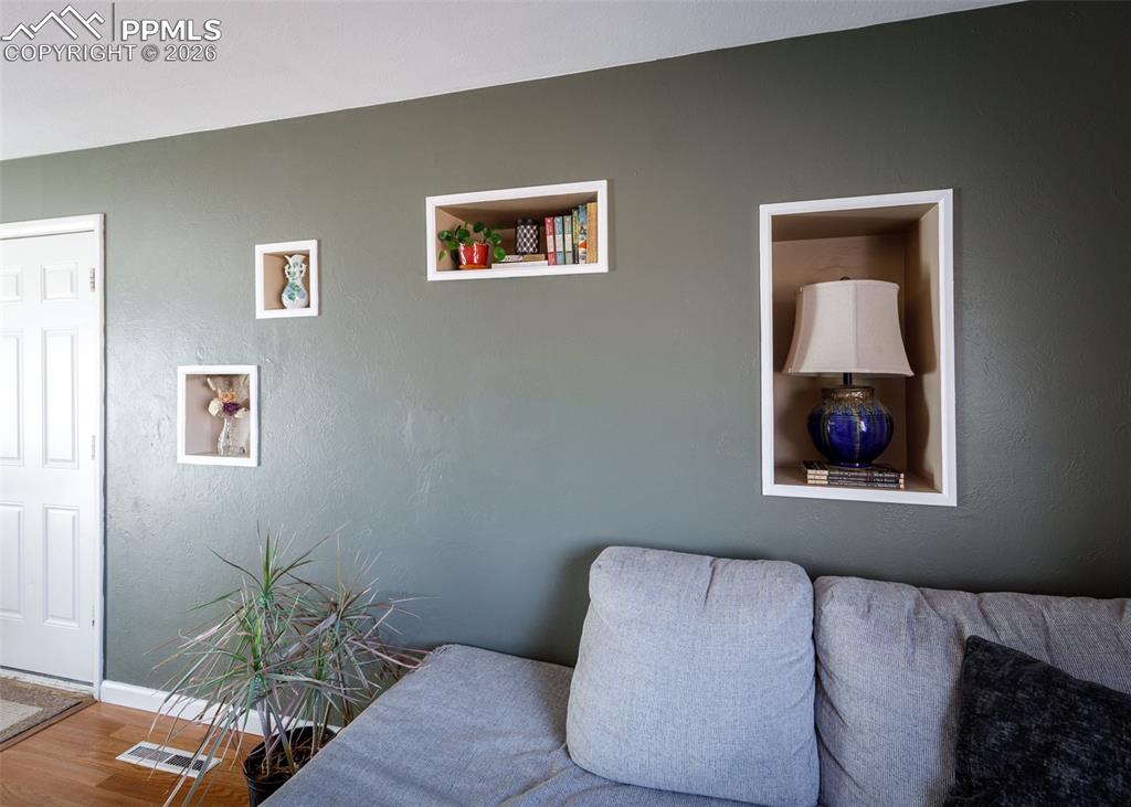 Image 10 of 39: Sitting room featuring a textured wall and wood finished floors