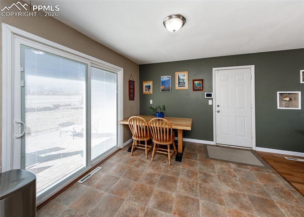 Image 19 of 39: Dining room featuring stone finish floors and baseboards