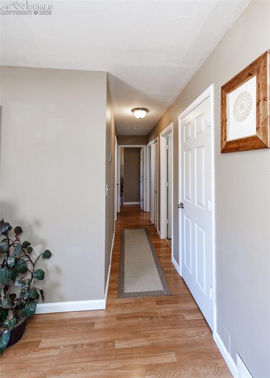Image 26 of 39: Corridor with light wood-style floors and baseboards