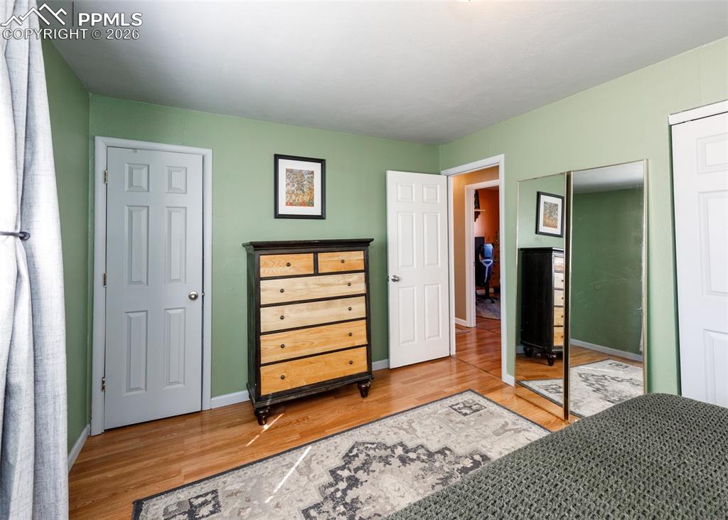 Image 29 of 39: Bedroom featuring light wood-type flooring and two closets