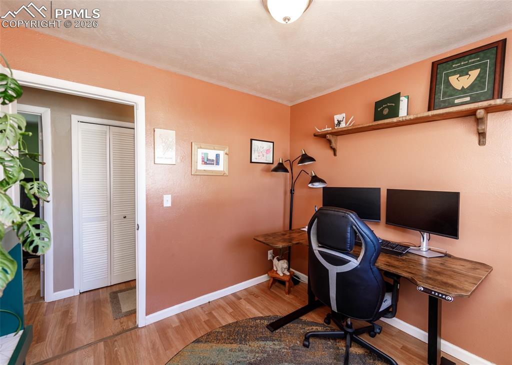 Image 33 of 39: Office area with light wood-style floors and baseboards