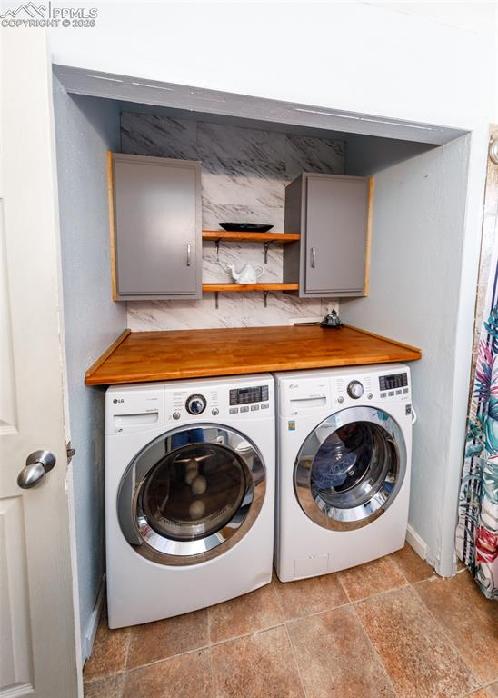 Image 39 of 39: Laundry area with washing machine and dryer and cabinet space