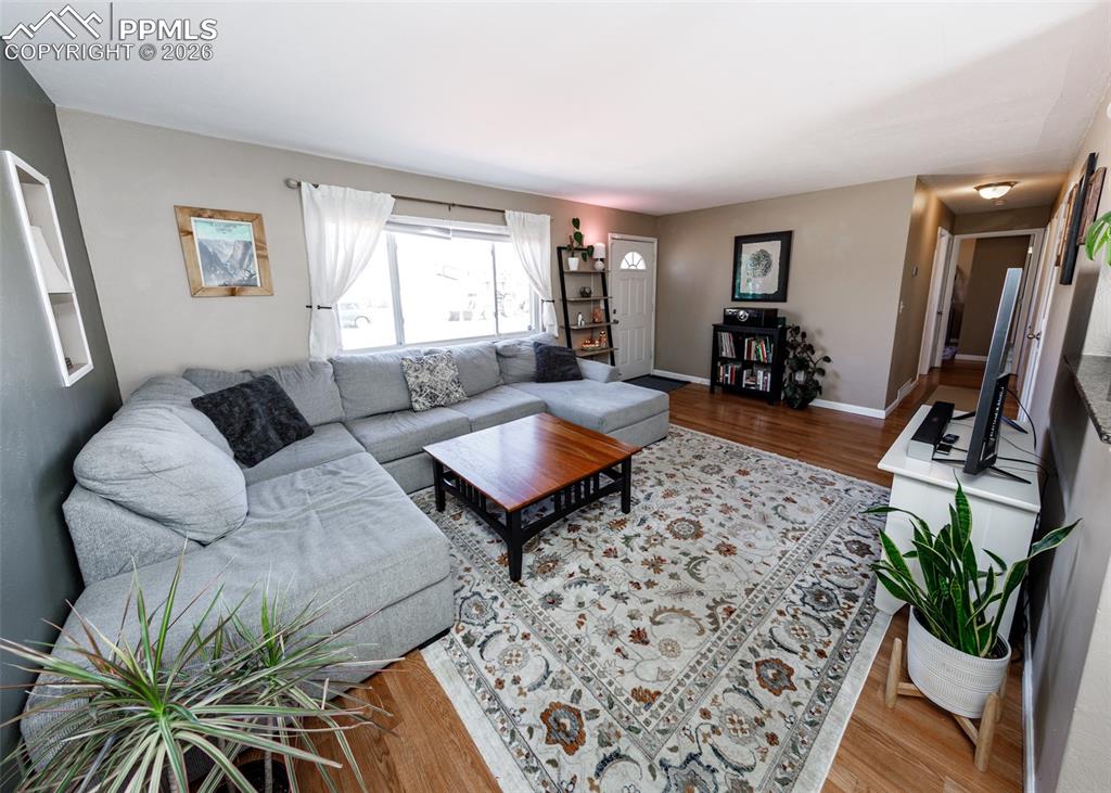 Image 8 of 39: Living room with wood finished floors and baseboards