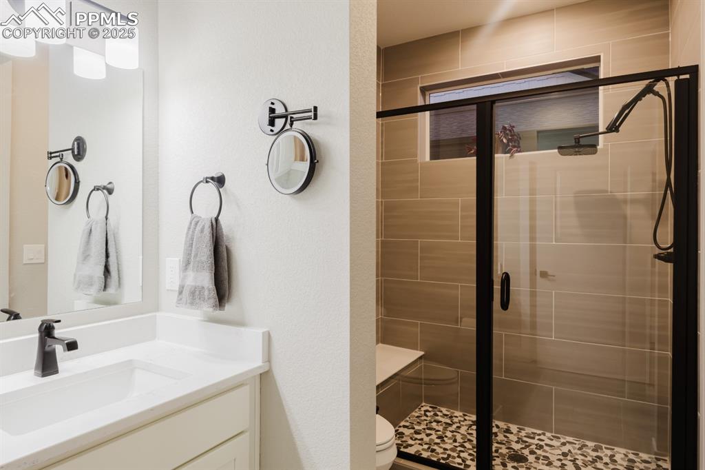 Image 14 of 31: The oversized shower in the primary bath has a rainhead shower and a built-