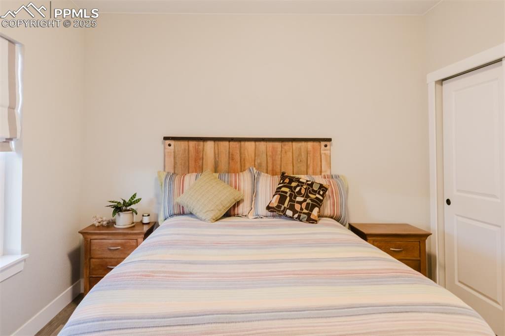 Image 16 of 31: The second main-floor bedroom has a double closet and lots of natural light