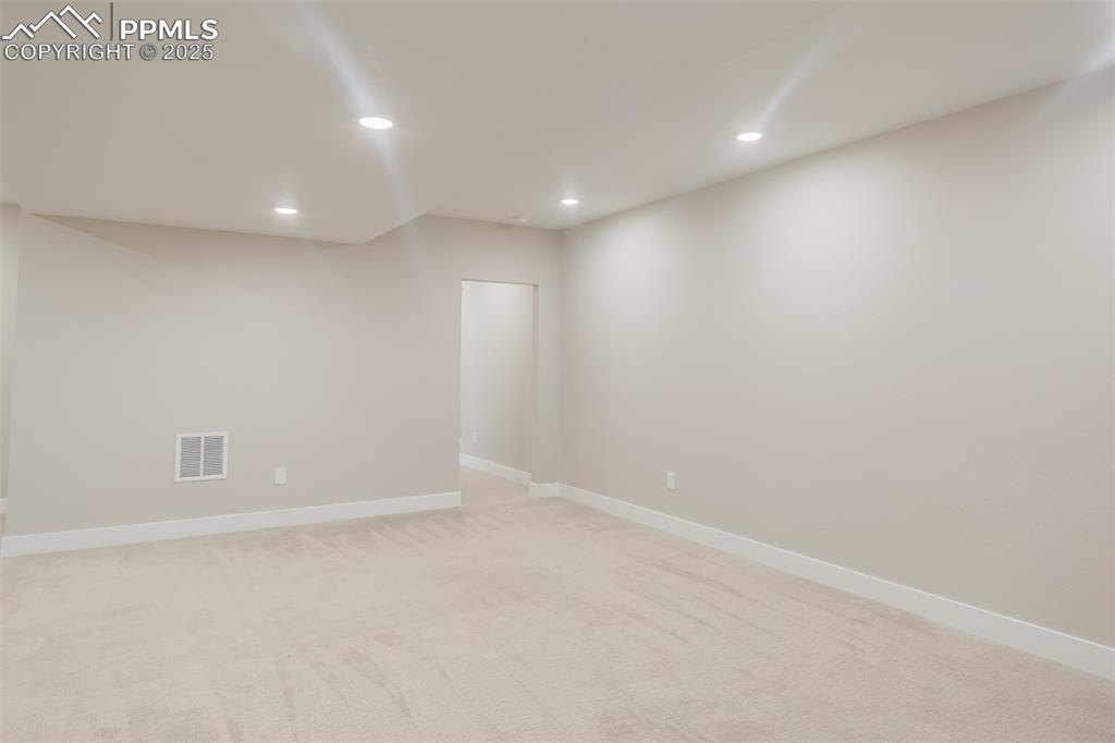 Image 22 of 31: View of the family room from the stairs, toward the back hallway leading to