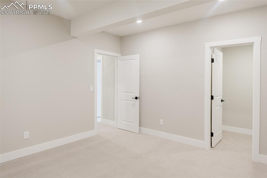 Image 27 of 31: The fourth bedroom is located on the basement level and has a walk-in close