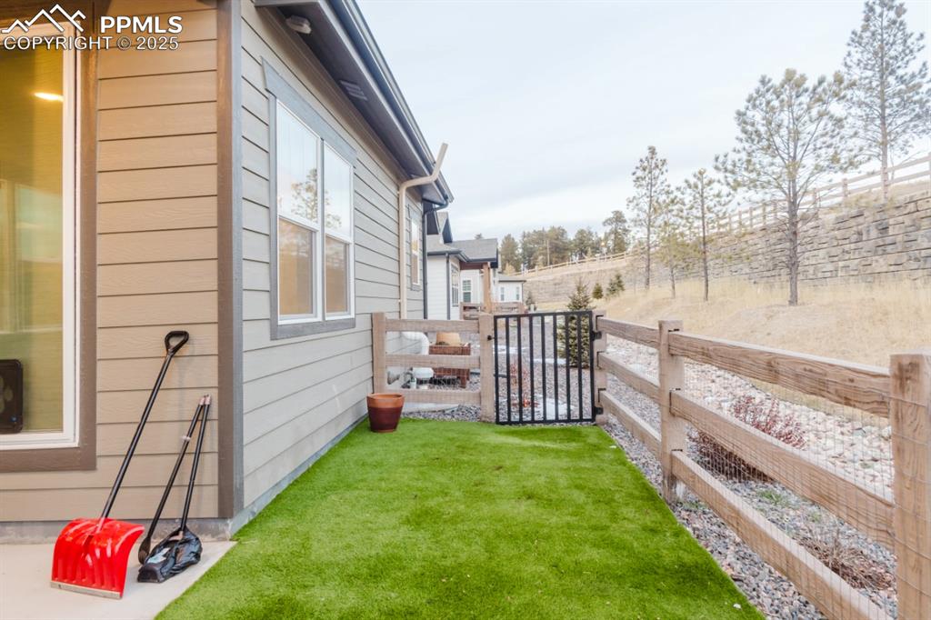 Image 30 of 31: Off the rear patio is a fenced area with artificial turf.