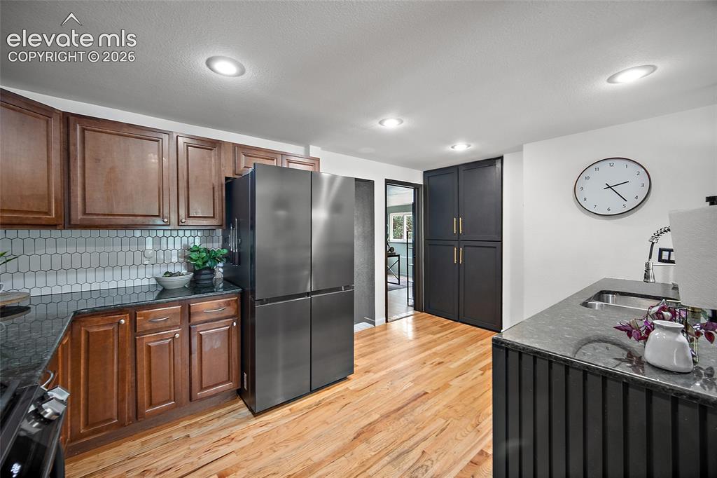 Image 12 of 43: Kitchen featuring light wood-finish flooring, recessed lighting, and a stai