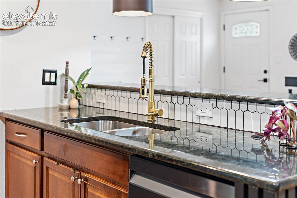 Image 13 of 43: Kitchen featuring a double basin stainless steel sink, a gold-finish pull-d
