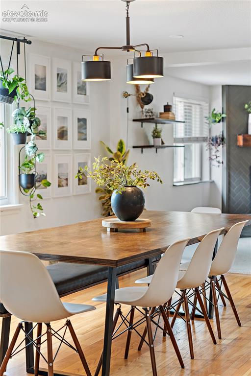 Image 15 of 43: Hardwood flooring complementing a wood-top dining table with a dark metal b