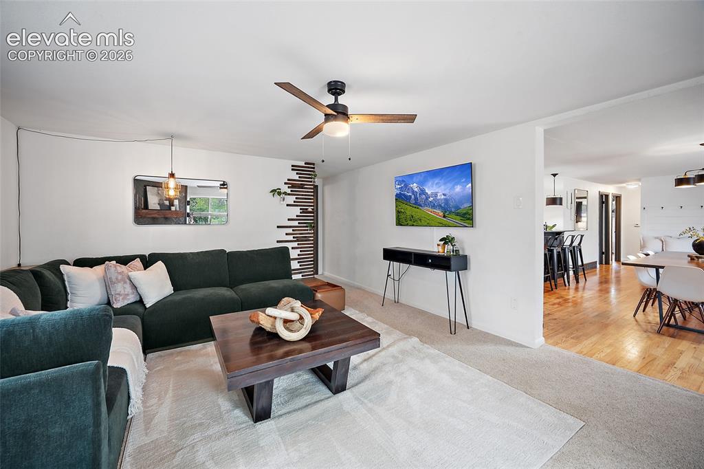 Image 16 of 43: Spacious living area featuring neutral carpeting and a ceiling fan with woo