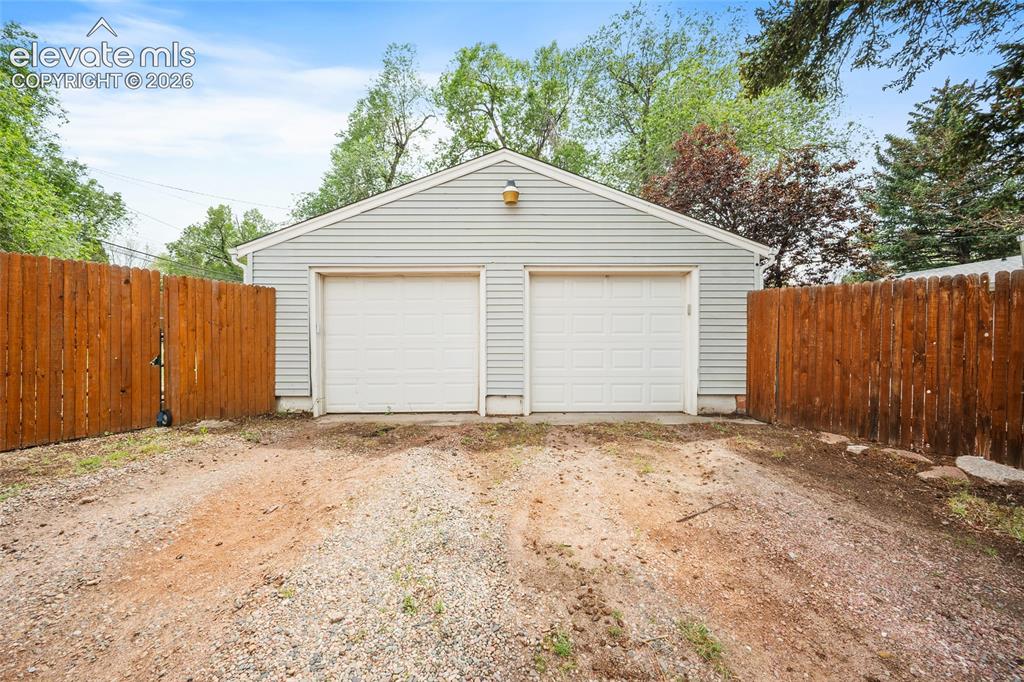 Image 2 of 43: Two-car detached garage with horizontal siding, two white garage doors, and