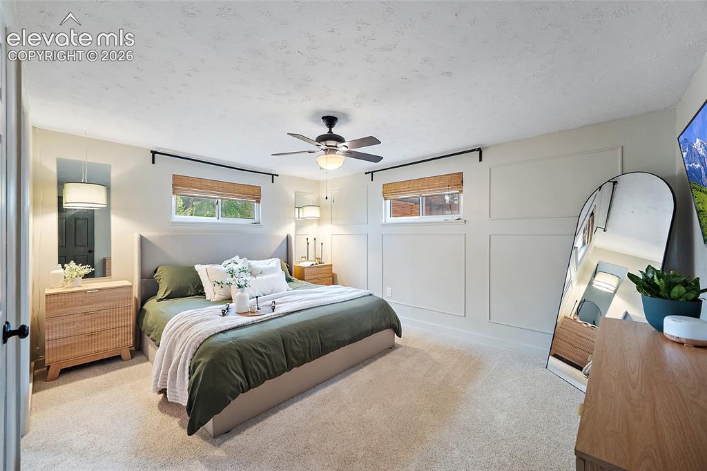 Image 22 of 43: Carpeted bedroom featuring a ceiling fan with integrated lighting, two wind