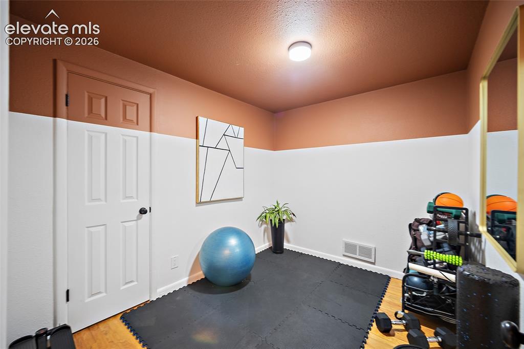 Image 31 of 43: Interior room with two-tone painted walls, wood-finish flooring, and ceilin
