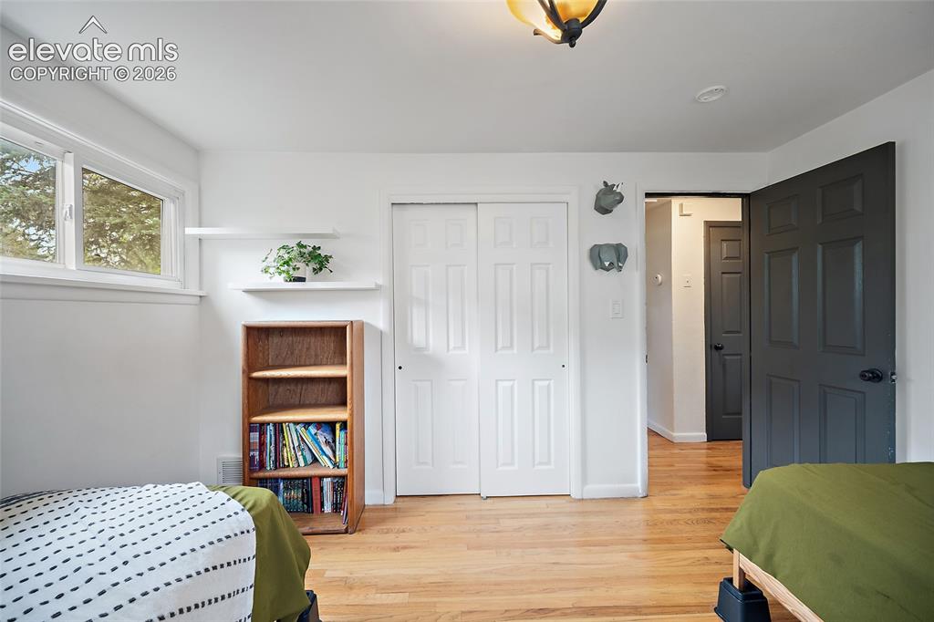 Image 33 of 43: Bright room with hardwood flooring and a white color palette