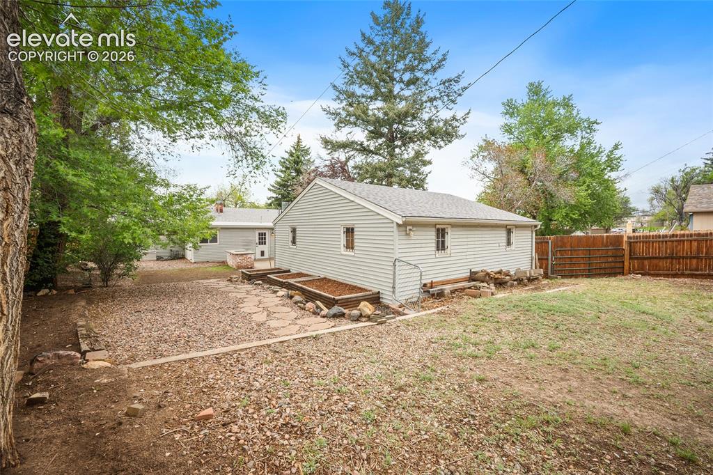 Image 39 of 43: Spacious backyard featuring a detached structure, privacy fencing, and matu