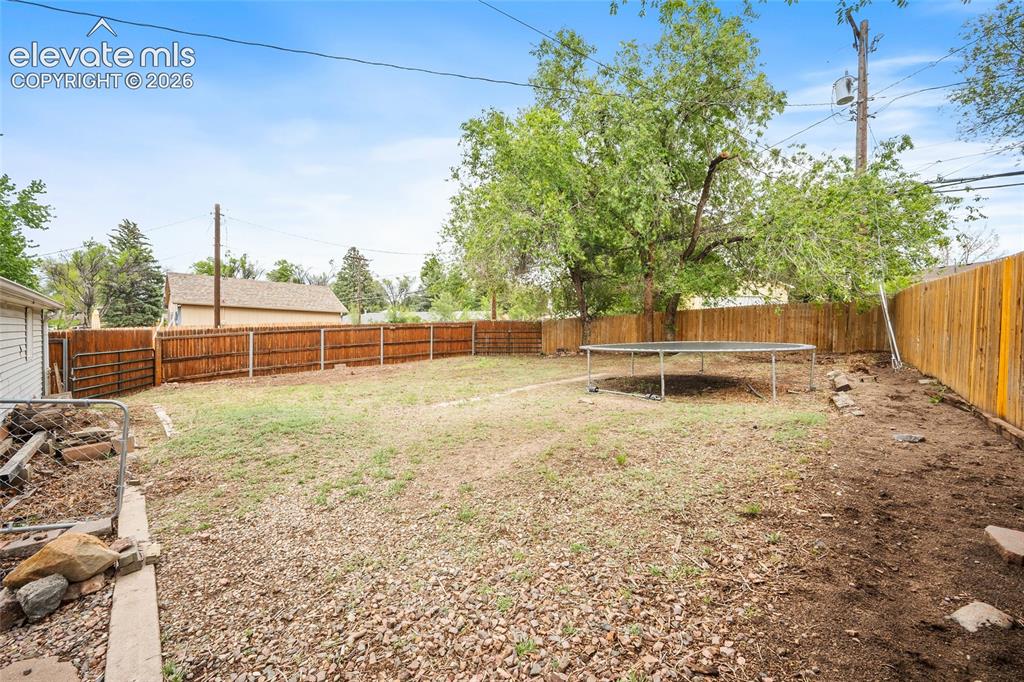 Image 41 of 43: Expansive backyard featuring a wood fence perimeter and mature trees
