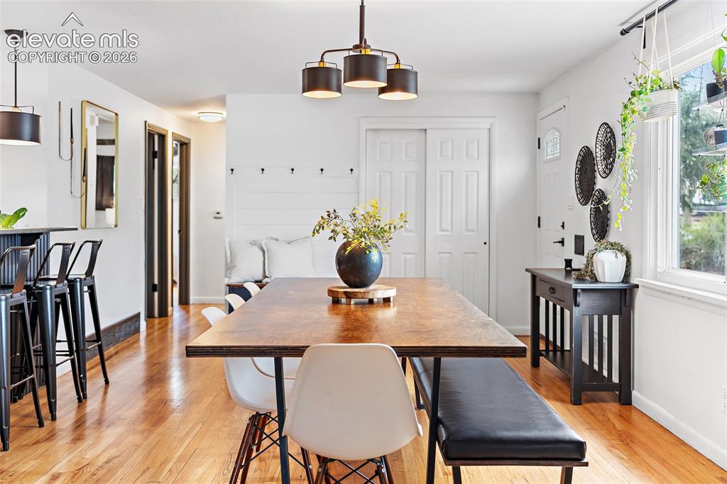 Image 7 of 43: Open-concept living space featuring wood-finish flooring, a contemporary ch