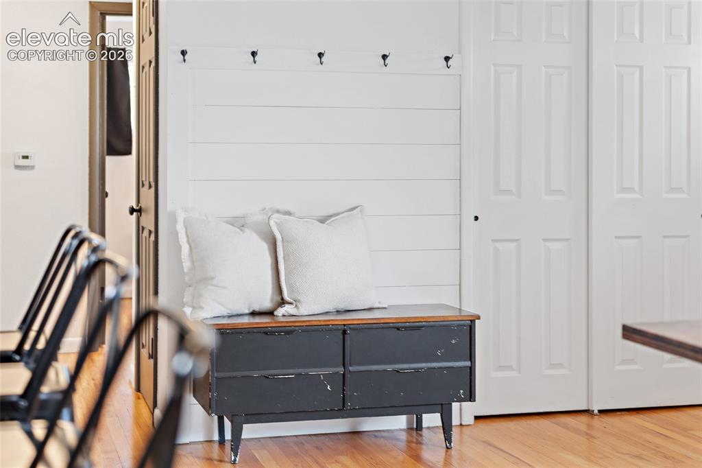 Image 8 of 43: Shiplap accent wall featuring integrated coat hooks