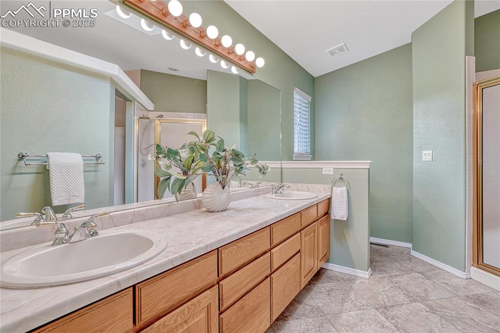 Image 23 of 38: Adjoining primary bathroom with walk-in shower...