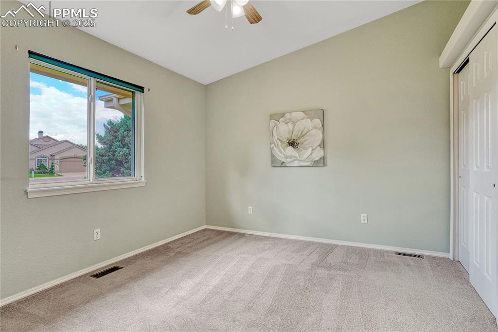 Image 25 of 38: Second bedroom with views of the adjacent open lot.