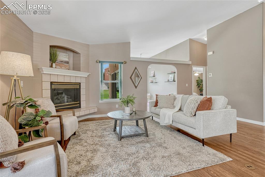Image 8 of 38: Great room has vaulted ceiling and gas fireplace.