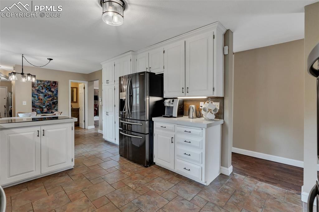 Image 10 of 41: Kitchen with white cabinetry, stainless steel refrigerator with ice dispens