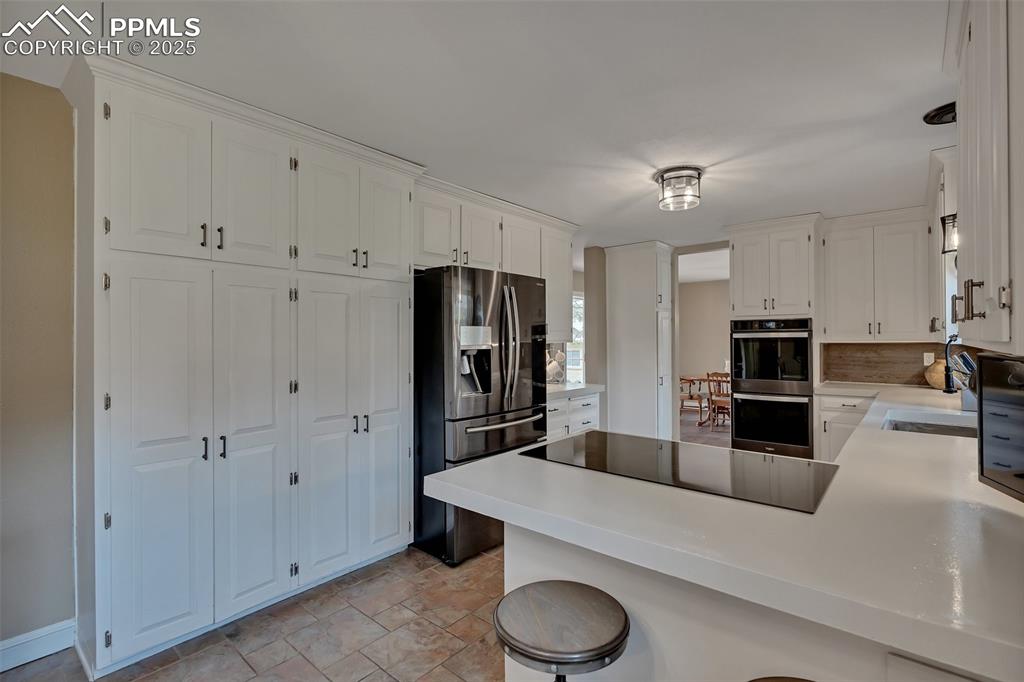 Image 11 of 41: Kitchen featuring white cabinetry, appliances with stainless steel finishes