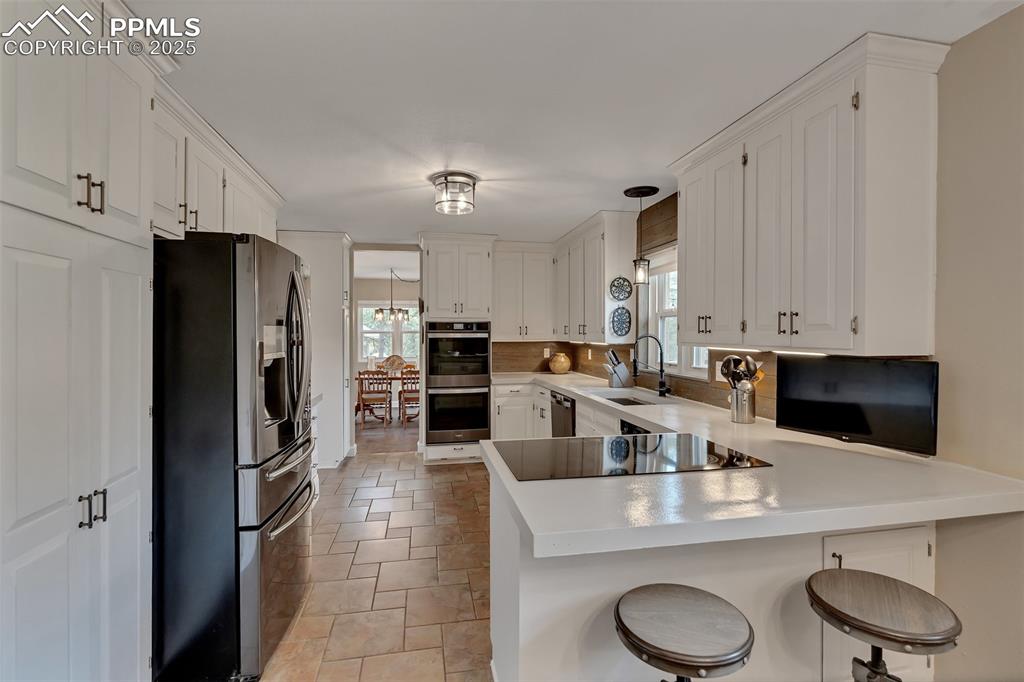 Image 12 of 41: Kitchen featuring a peninsula, a breakfast bar area, stainless steel applia