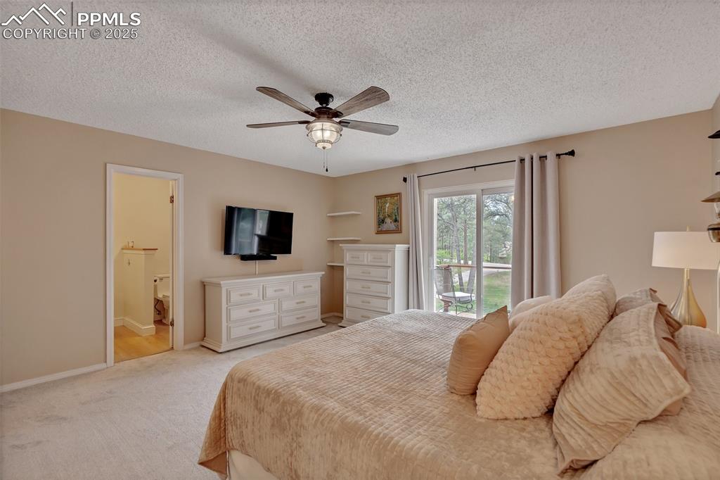 Image 18 of 41: Carpeted bedroom with access to outside, a ceiling fan, a textured ceiling,