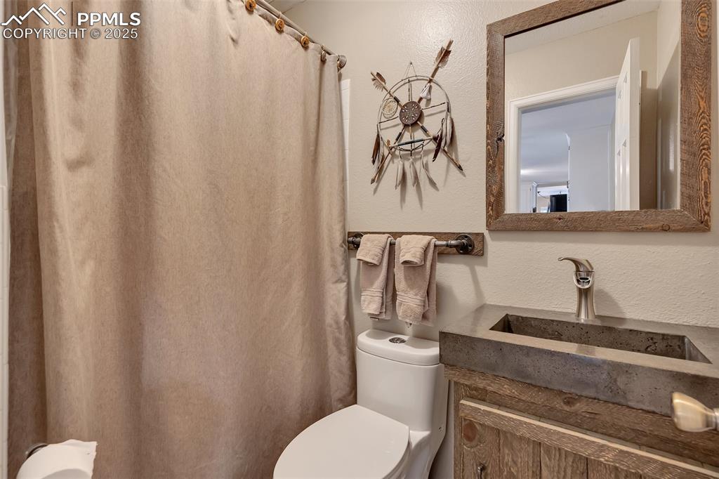 Image 23 of 41: Full bathroom with a textured wall, vanity, and a shower with shower curtai
