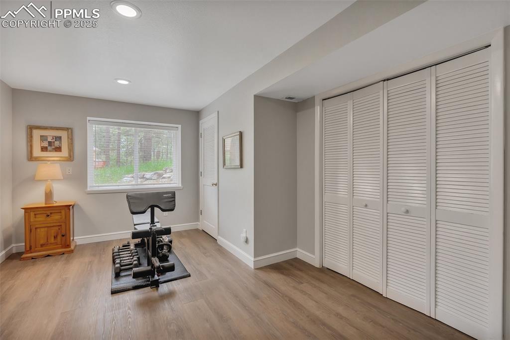 Image 27 of 41: Workout area featuring light wood-style flooring and recessed lighting