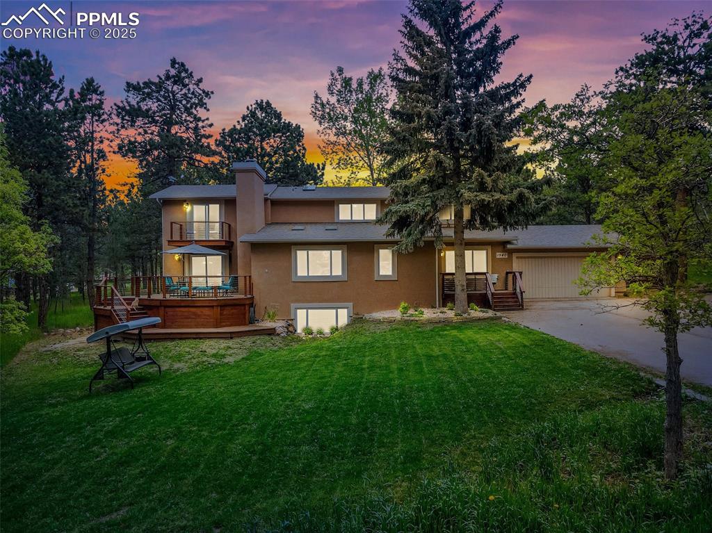 Image 29 of 41: View of front of property featuring a front yard, stucco siding, a chimney,
