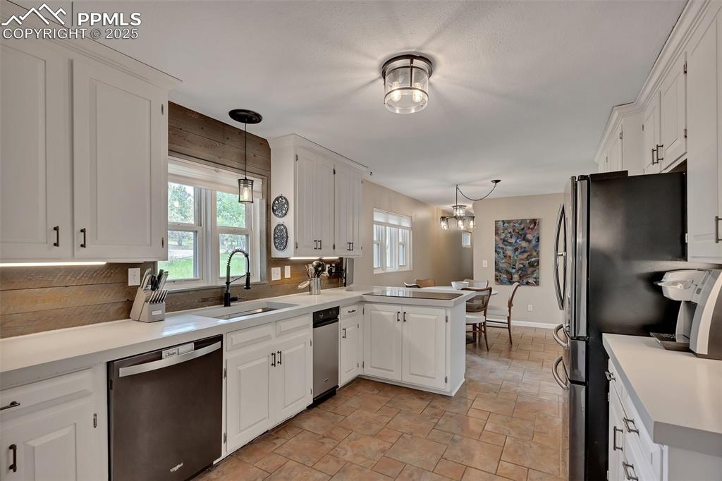 Image 3 of 41: Kitchen with pendant lighting, light countertops, and white cabinetry