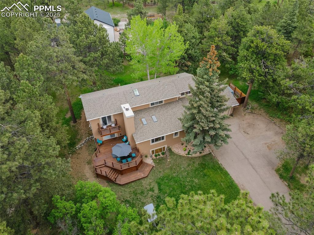 Image 31 of 41: Aerial view of property and surrounding area with a tree filled landscape