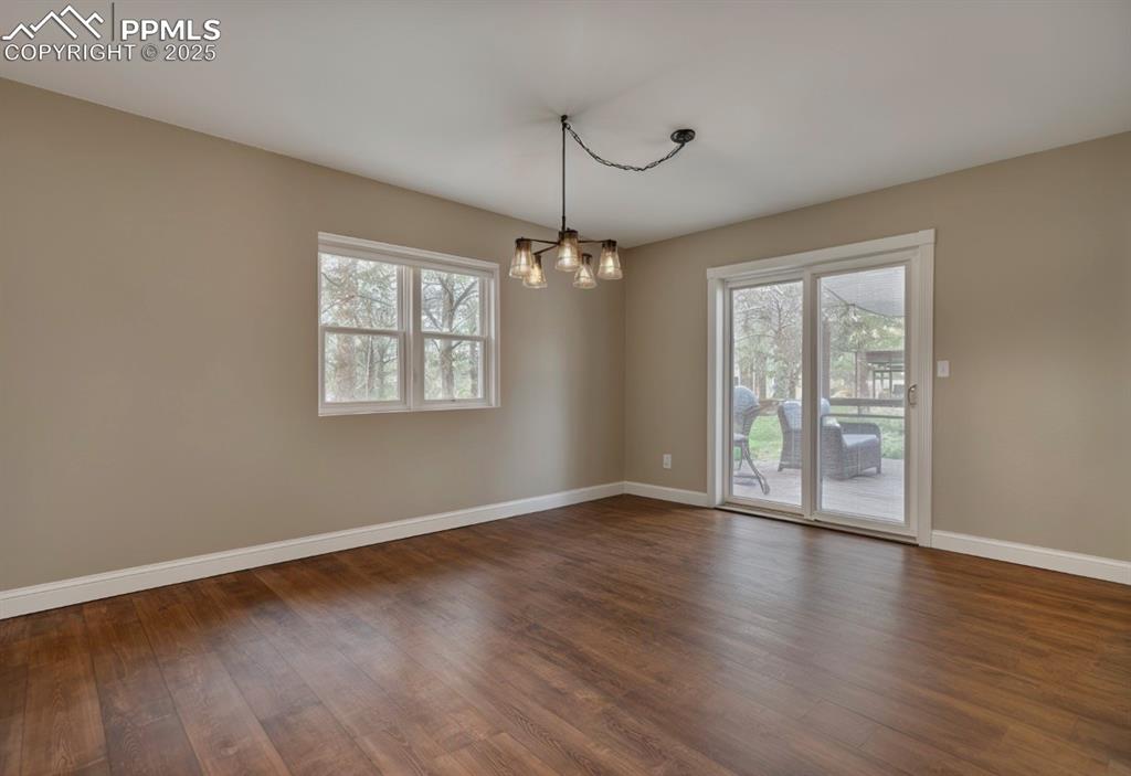 Image 9 of 41: Unfurnished dining area featuring dark wood finished floors and a chandelie
