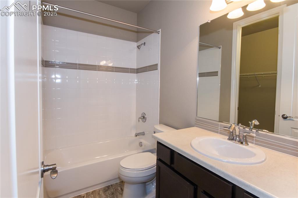 Image 15 of 28: Bathroom featuring toilet, vanity, and bathing tub / shower combination