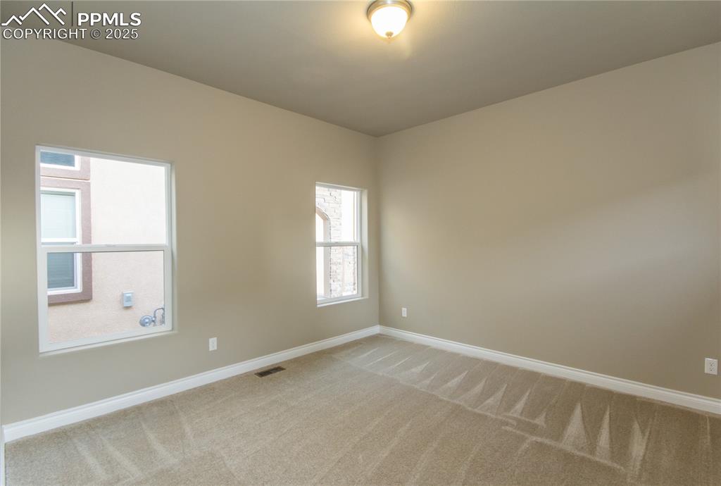Image 16 of 28: Unfurnished room featuring baseboards, visible vents, and light colored car