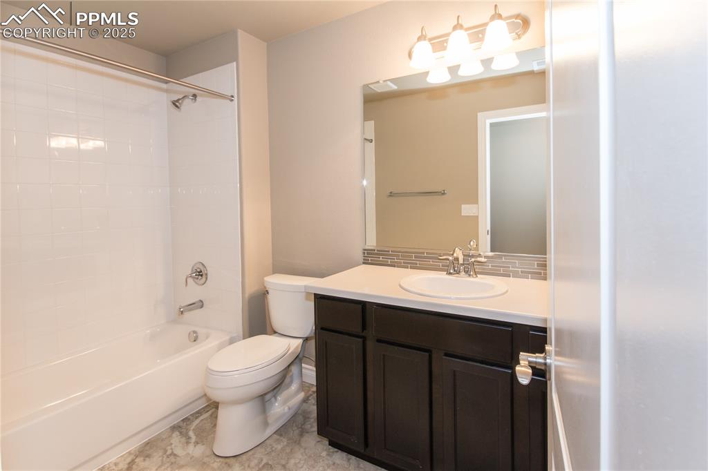 Image 27 of 28: Full bathroom featuring shower / tub combination, toilet, vanity, and decor